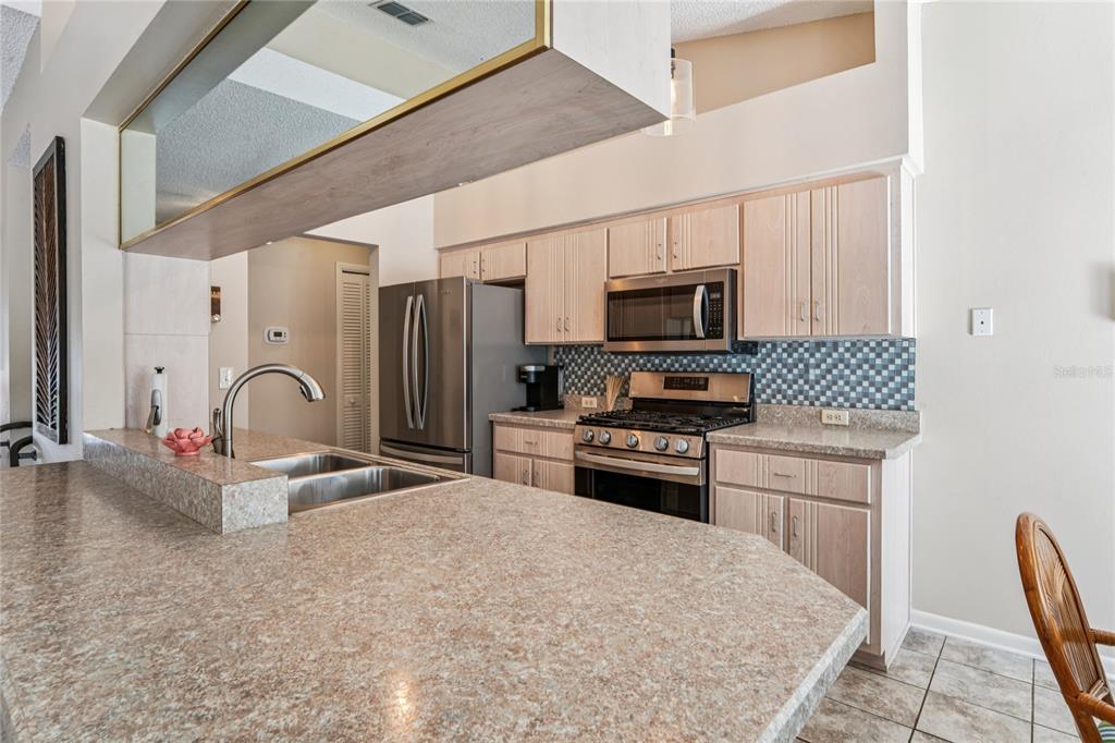 6324 India Drive Spring Hill, FL 34608 - Photo 14 of 68 a kitchen with stainless steel appliances a stove refrigerator sink and cabinets