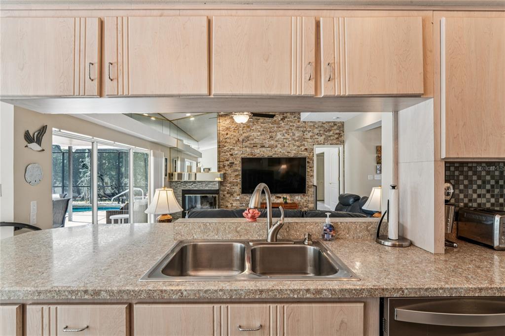 6324 India Drive Spring Hill, FL 34608 - Photo 16 of 68 a kitchen with granite countertop a sink and a stove next to a white cabinet