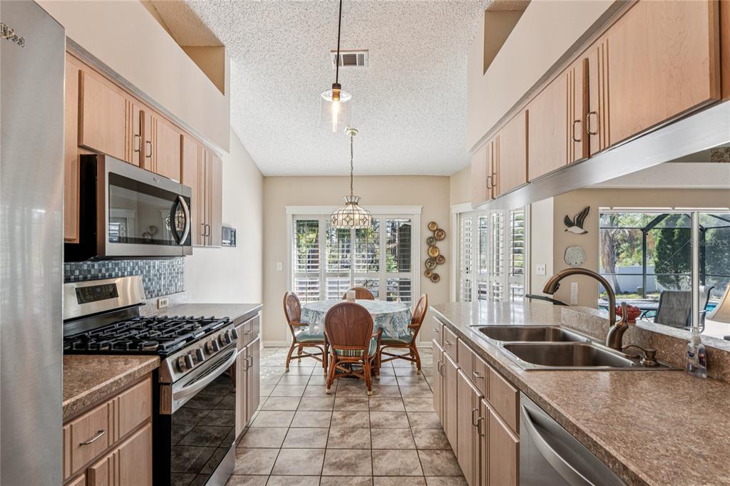 6324 India Drive Spring Hill, FL 34608 - Photo 18 of 68 a kitchen with stove a sink and chairs