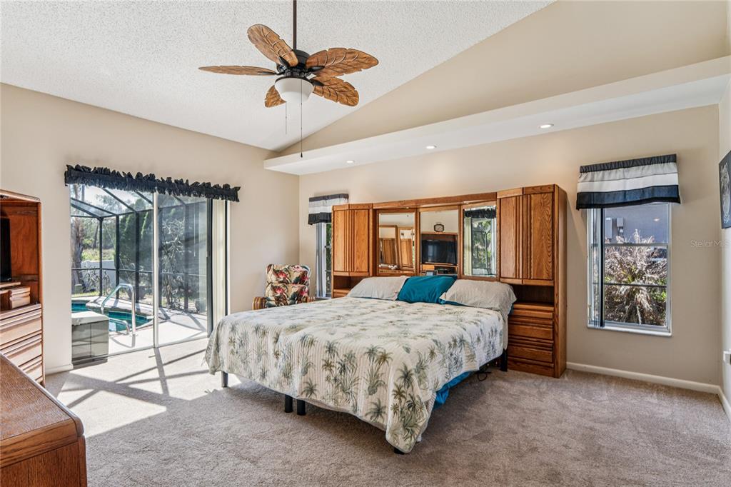 6324 India Drive Spring Hill, FL 34608 - Photo 27 of 68 a bedroom with a large bed and a chandelier fan