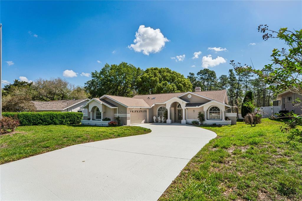 6324 India Drive Spring Hill, FL 34608 - Photo 56 of 68 a front view of a house with a yard and potted plants