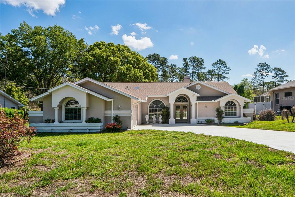 6324 India Drive Spring Hill, FL 34608 - Photo 57 of 68 a front view of a house with a yard and garage