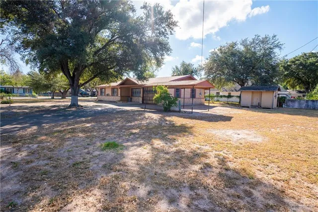 a front view of a house with a yard and trees