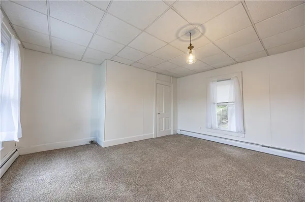 an empty room with windows and cabinet