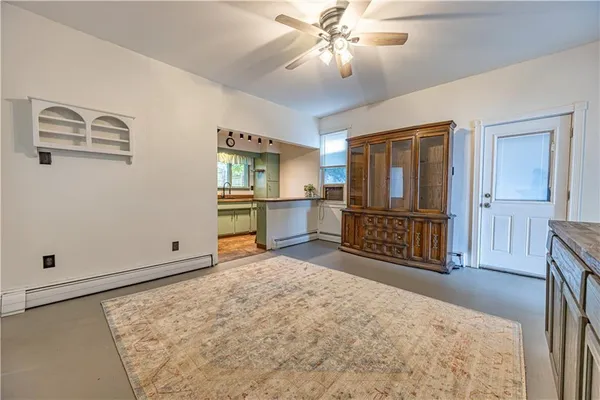 a view of a livingroom with wooden floor and a ceiling fan