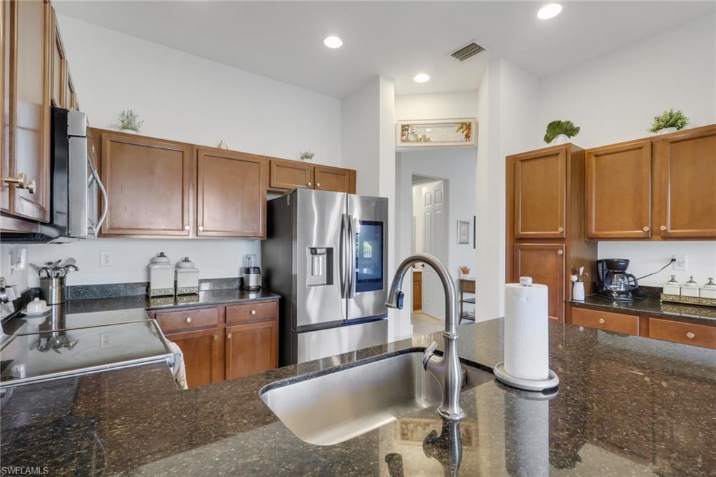 5289 Beckton Road Immokalee, FL 34142 - Photo 11 of 37 a kitchen with stainless steel appliances granite countertop a sink a stove and cabinets