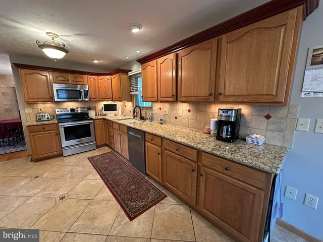 a living room with furniture and a refrigerator