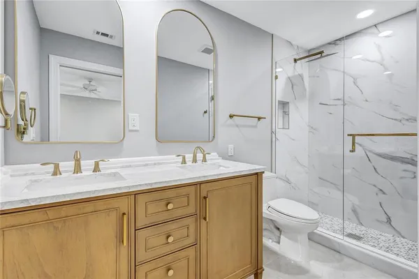 a bathroom with a granite countertop sink toilet and shower