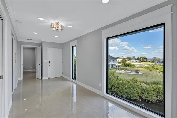 en view of an empty room with a large window and front door