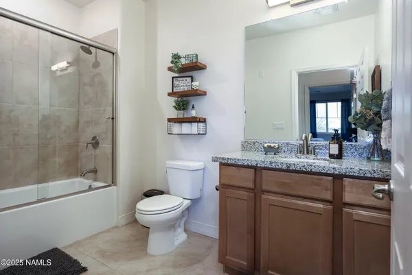 a bathroom with a granite countertop sink a toilet and a shower