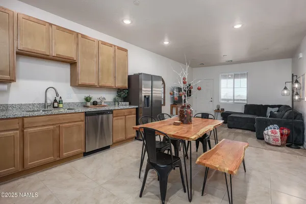 a kitchen with a dining table chairs and refrigerator