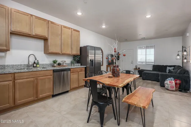 a kitchen with a dining table chairs and refrigerator
