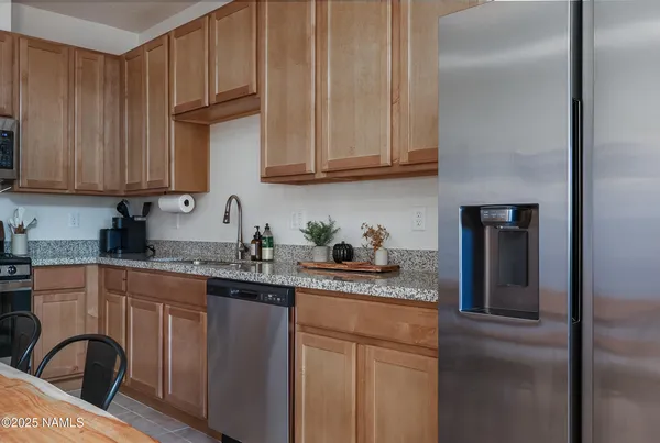 a kitchen with stainless steel appliances granite countertop a sink a stove and refrigerator