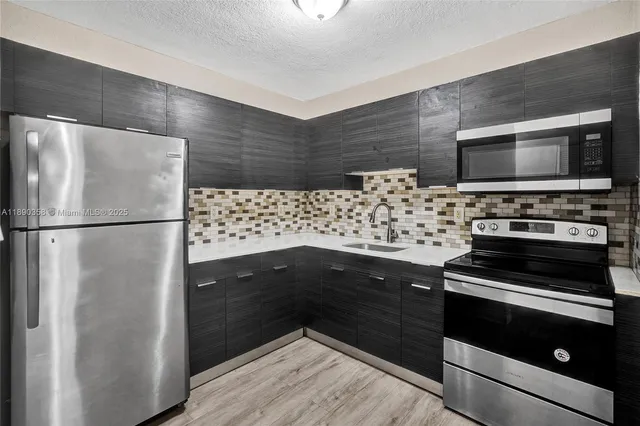 a kitchen with wooden cabinets and stainless steel appliances