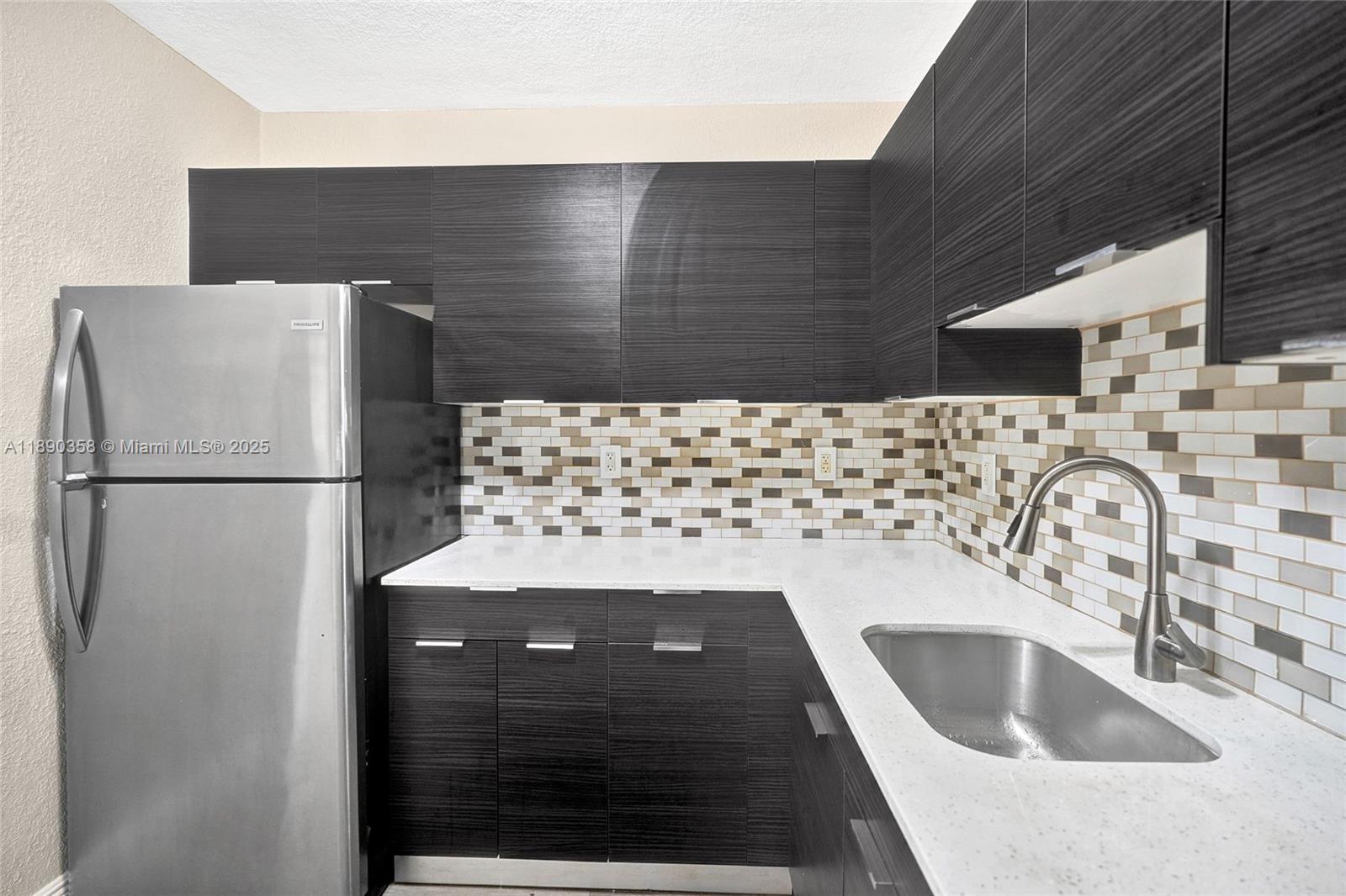 2731 Northwest 1st Street, Unit 3 Pompano Beach, FL 33069 - Photo 13 of 20 a kitchen with a sink and a refrigerator