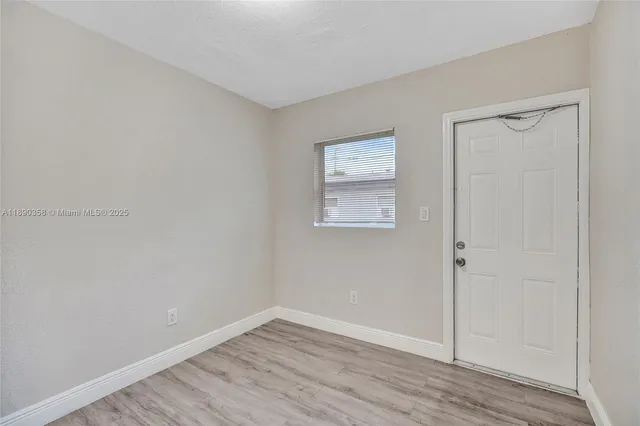 an empty room with wooden floor and closet