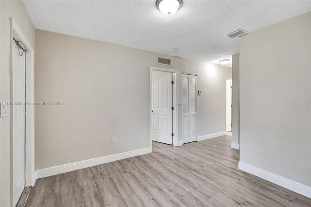 a view of an empty room and wooden floor