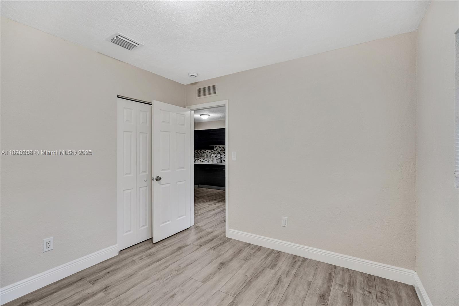 2731 Northwest 1st Street, Unit 3 Pompano Beach, FL 33069 - Photo 10 of 20 a view of an empty room with wooden floor