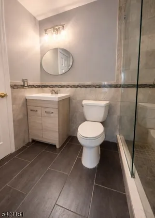 a spacious bathroom with a granite countertop toilet sink and mirror
