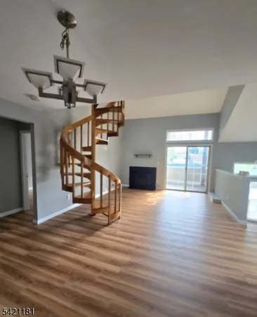 a view of empty room with wooden floor window and fireplace