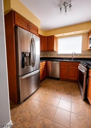a kitchen with stainless steel appliances granite countertop a refrigerator and a sink