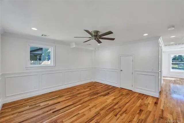 a view of a livingroom with wooden floor and a ceiling fan