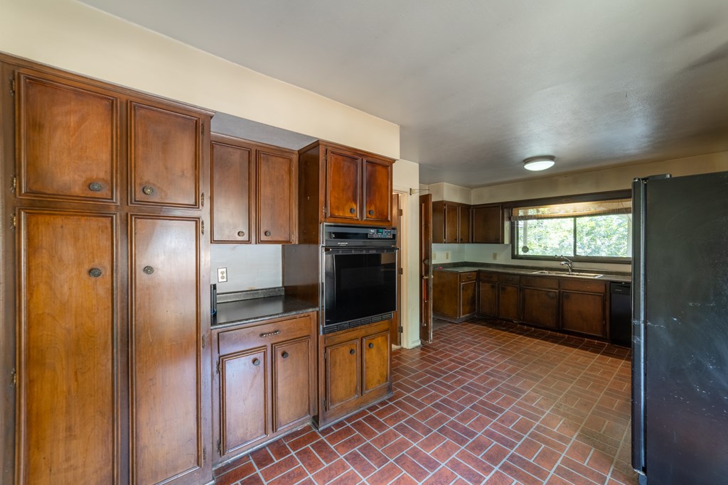2724 Edgewood Road Columbus, GA 31906 - Photo 6 of 22 a kitchen with granite countertop a refrigerator and cabinets