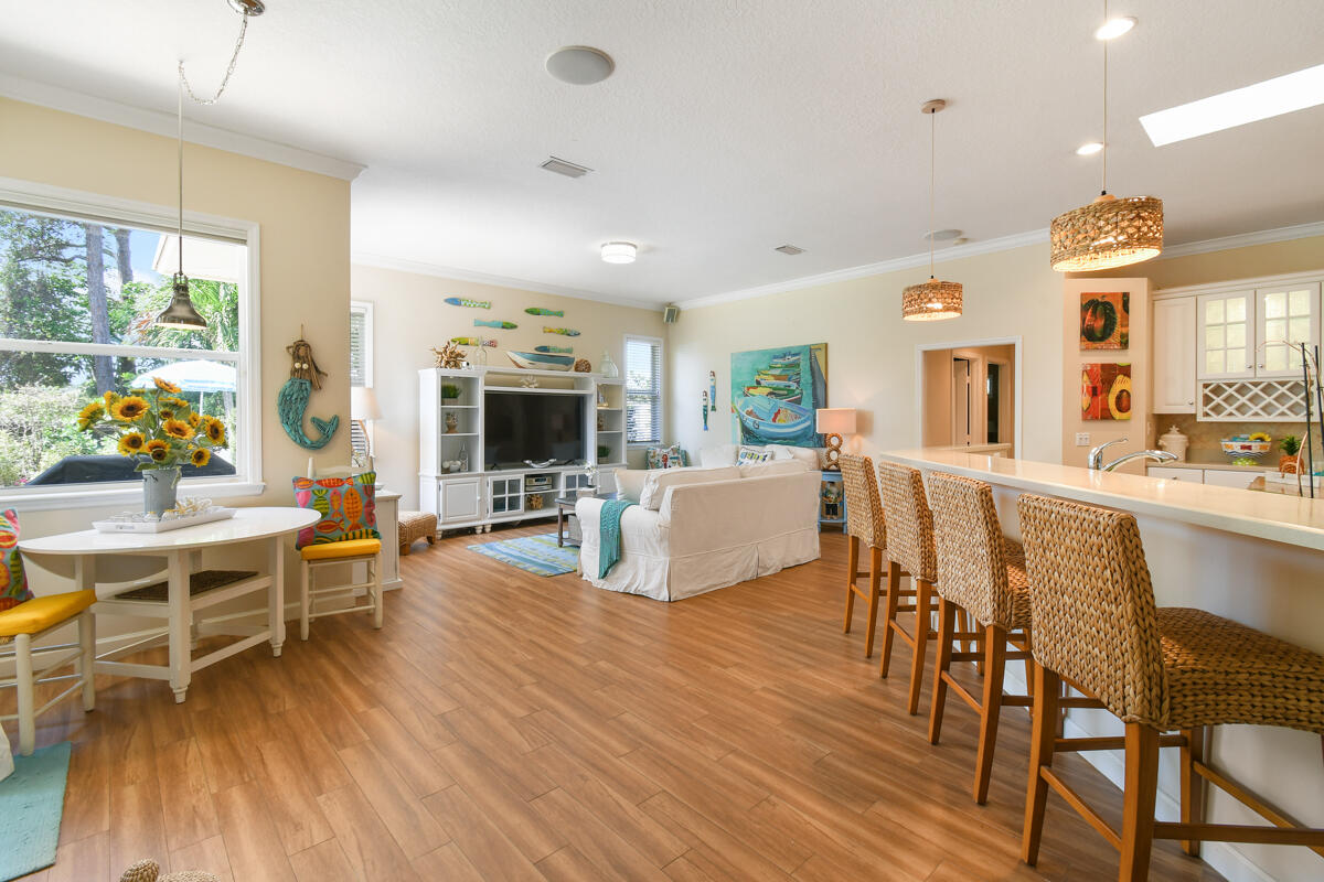 7831 Southeast Windjammer Way Hobe Sound, FL 33455 - Photo 13 of 80 a living room with furniture wooden floor and a kitchen view