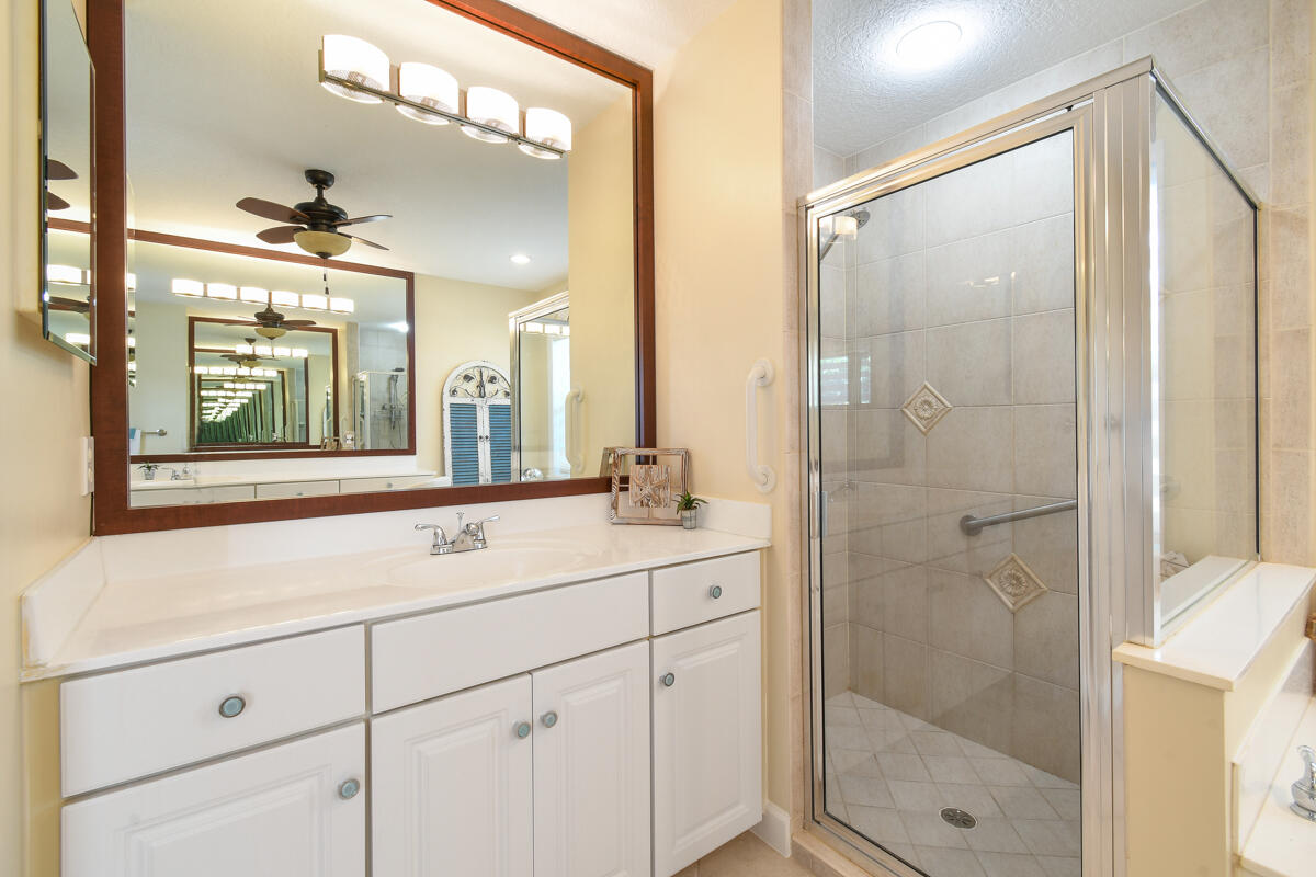 7831 Southeast Windjammer Way Hobe Sound, FL 33455 - Photo 32 of 80 a bathroom with a shower sink and mirror