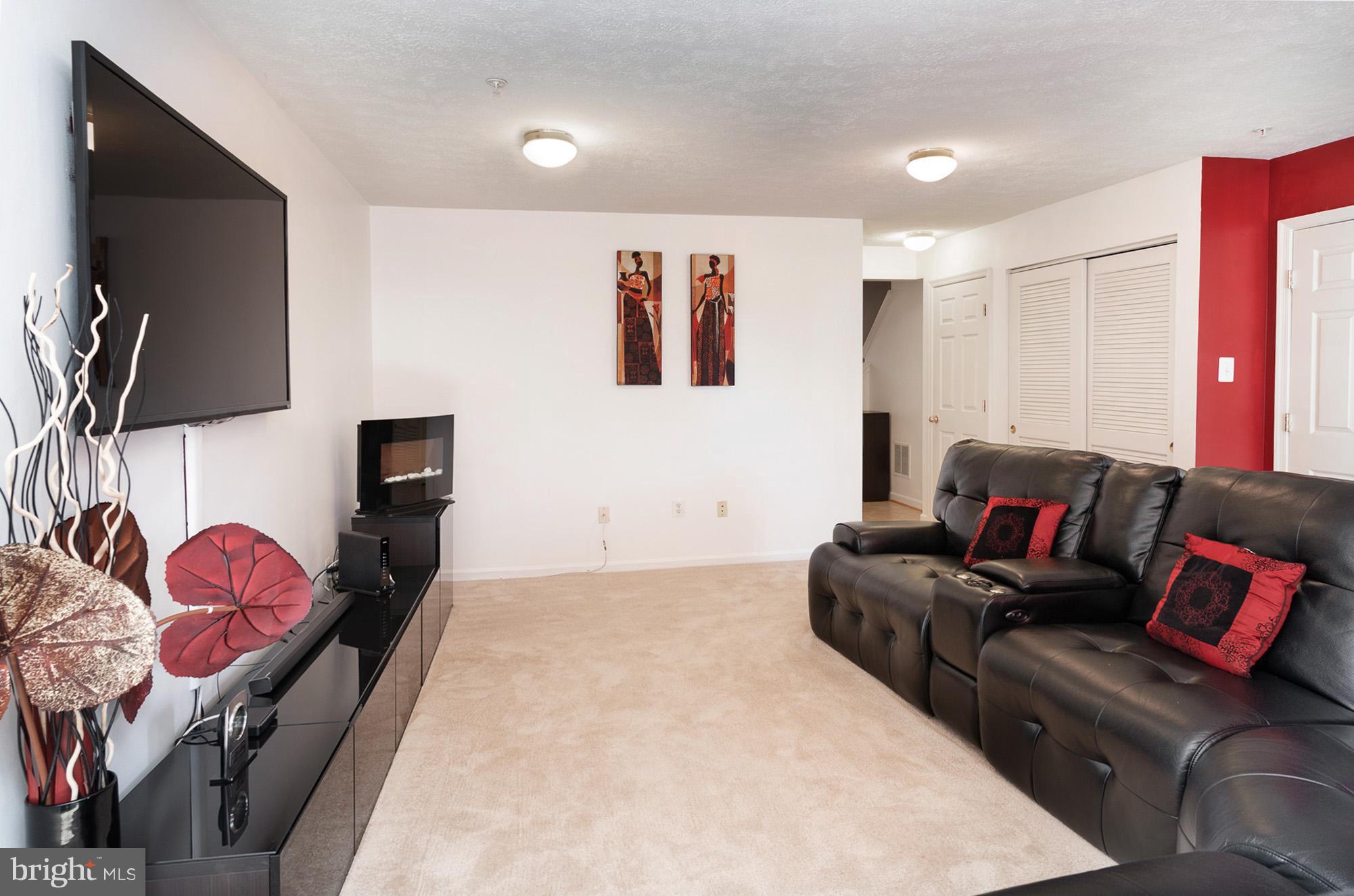 802 Tipton Road Middle River, MD 21220 - Photo 23 of 30 a living room with furniture a flat screen tv and red wall
