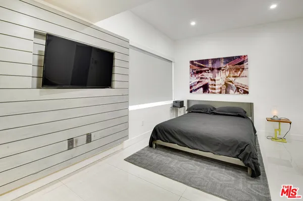a bedroom with a bed and a painting on the wall