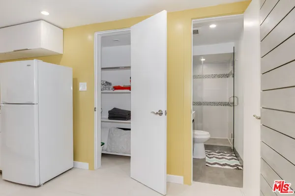 a bathroom with a refrigerator and a sink