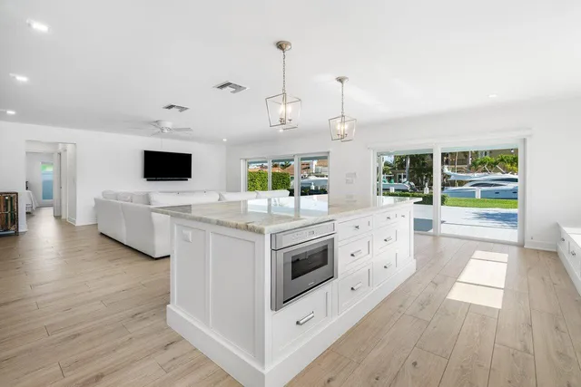 a kitchen with stainless steel appliances kitchen island granite countertop a stove and a wooden floors