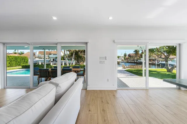a living room with hardwood floor and large windows