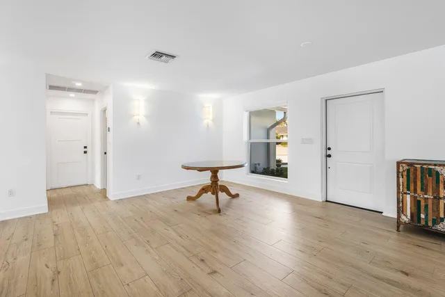 a living room with hard wood floors and a table