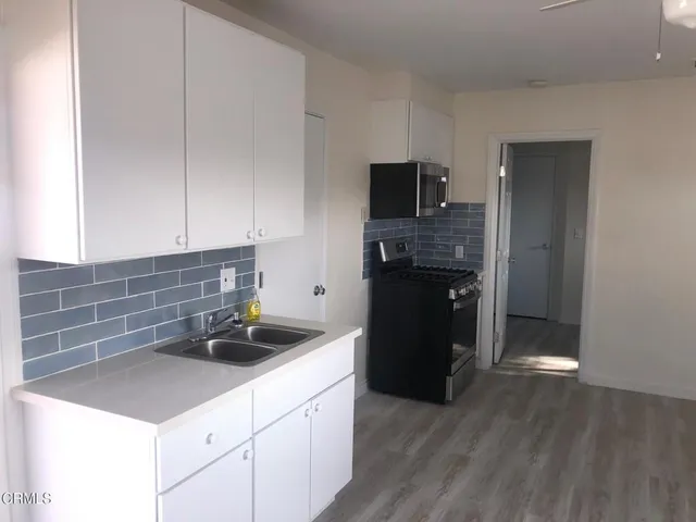 a kitchen with a sink and a stove top oven