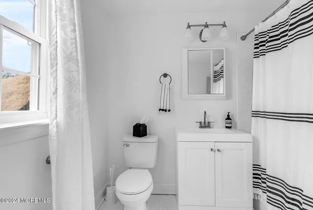 a living room with furniture and a large window with kitchen view
