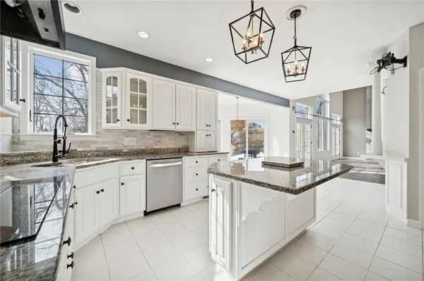 a kitchen with stainless steel appliances granite countertop a sink a stove and cabinets
