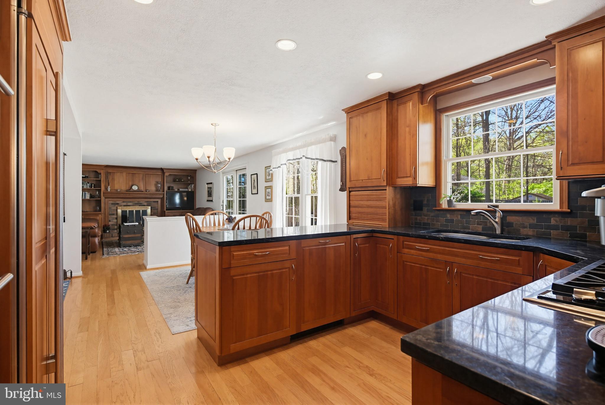 1017 Windmill Lane Silver Spring, MD 20905 - Photo 14 of 57 a large kitchen with kitchen island granite countertop wooden floors and wide window