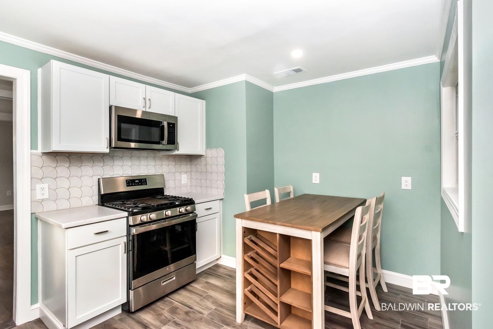 2157 Homewood Street Mobile, AL 36606 - Photo 6 of 36 Kitchen featuring light wood-style flooring, visible vents, white cabinets, appliances with stainless steel finishes, and backsplash
