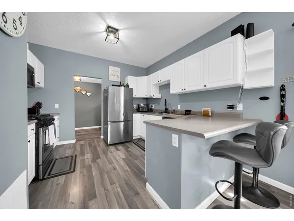 a open kitchen with cabinets a refrigerator and a stove top oven