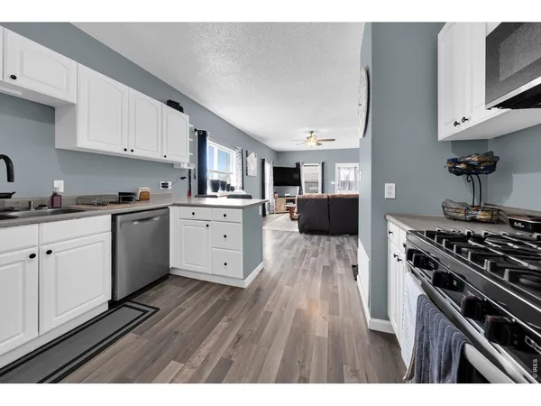 a kitchen with cabinets wooden floor and appliances