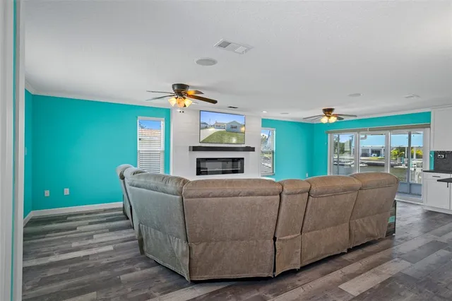 a living room with furniture kitchen view and a wooden floor