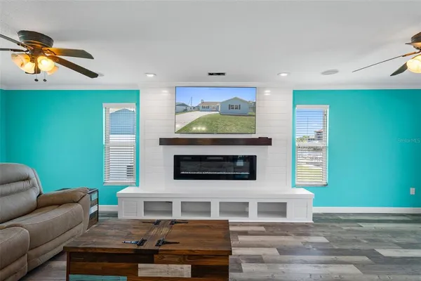 a open kitchen with wooden floor and a ceiling fan