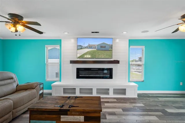 a open kitchen with wooden floor and a ceiling fan