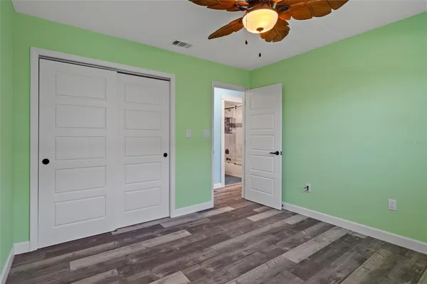 a view of a room with a ceiling fan and a bookshelf