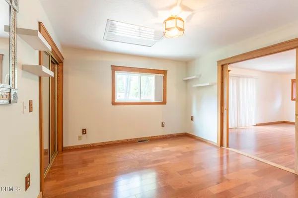 an empty room with windows and fan