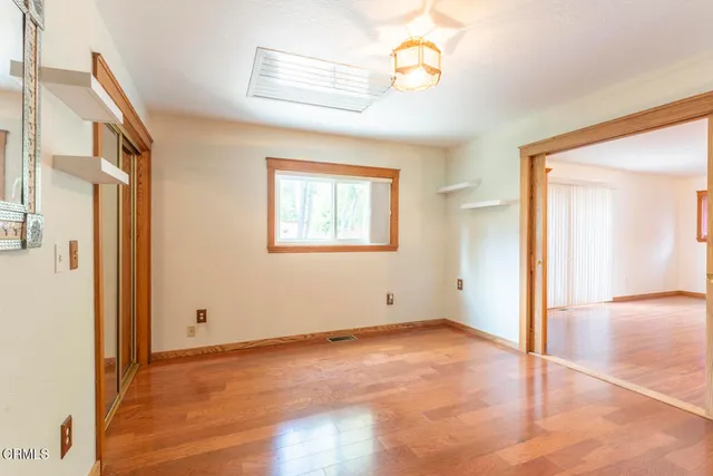 an empty room with windows and fan