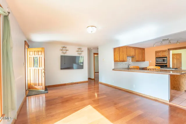 a view of a kitchen with wooden floor and a kitchen