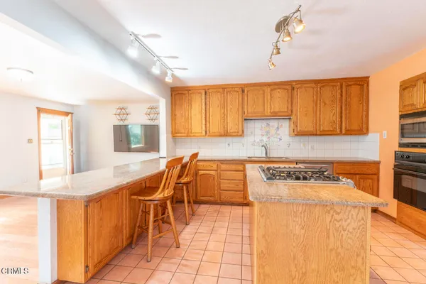 a kitchen with stainless steel appliances granite countertop a sink a stove counter space and cabinets
